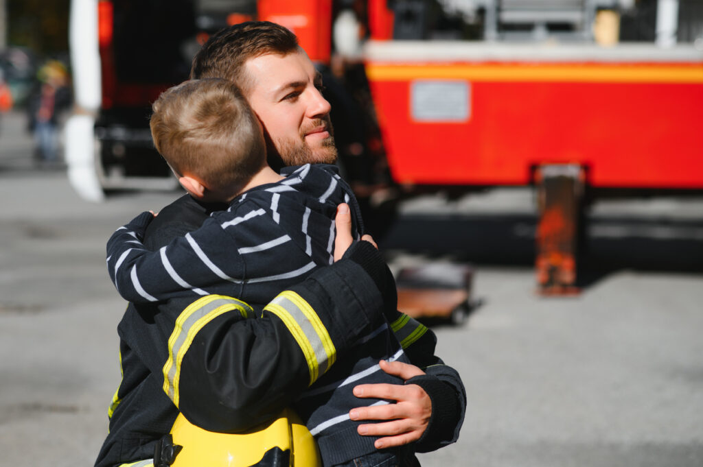 firefighter hugging a child